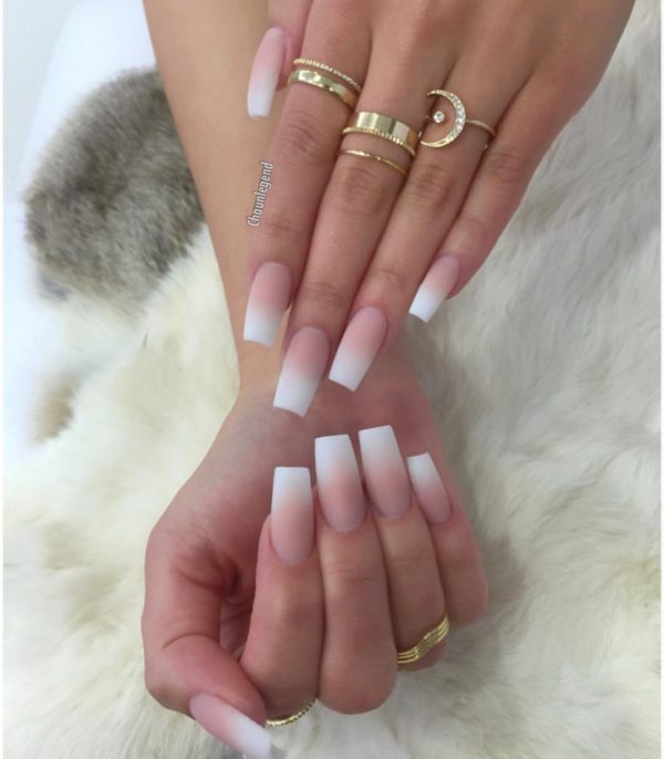 Matte pink and white ombre coffin nails long with gold rings on two hands