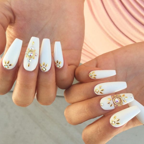 white and gold coffin nails adorned with rhinestones & goldy embellishments