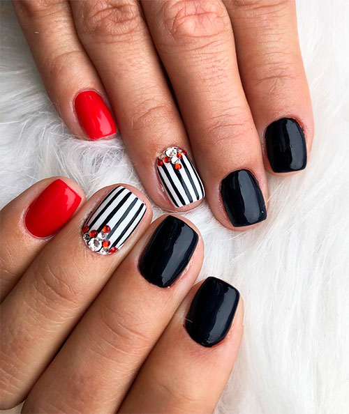 short red nails, short white striped nails adorned with some crystals, and short black nails for spring 2019