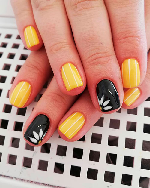 Cute white strips on yellow nails with an accent black floral nail for spring 2019
