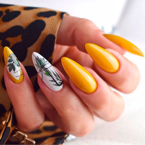 Awesome long almond yellow nails with green leaves on an accent white nail Awesome long almond yellow nails with green leaves on an accent white nail