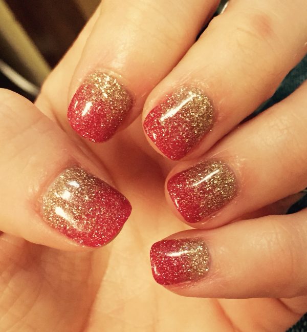 Red nails with spread gold glitter touches, red and gold nails