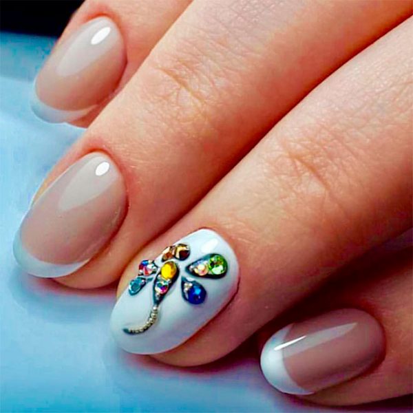 Cute round modern French tip nails with an accent white round nail adorned with crystal