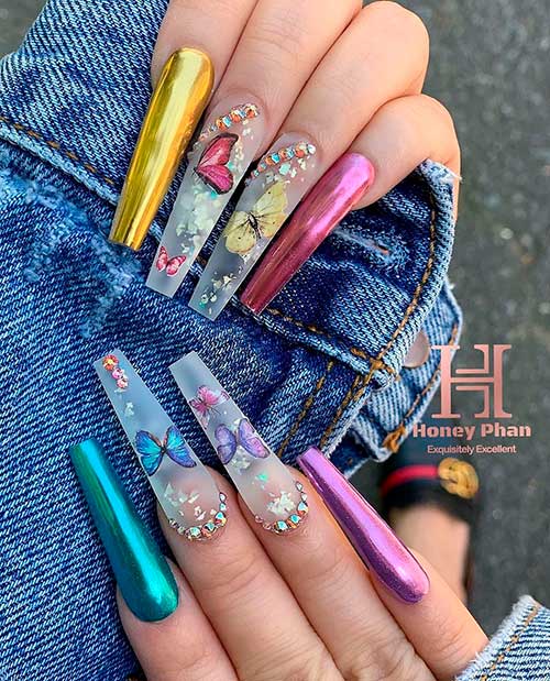 Cute multi colored chrome nails with butterfly decals, glitter, and rhinestones!