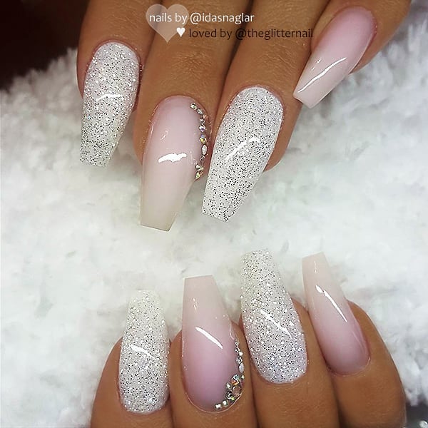 Amazing pink and white ombre coffin nails design with two glitter nails and rhinestones on accent nail