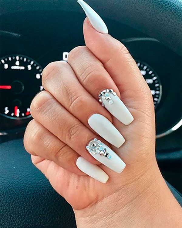 Cute matte white coffin nails with diamonds on light skin