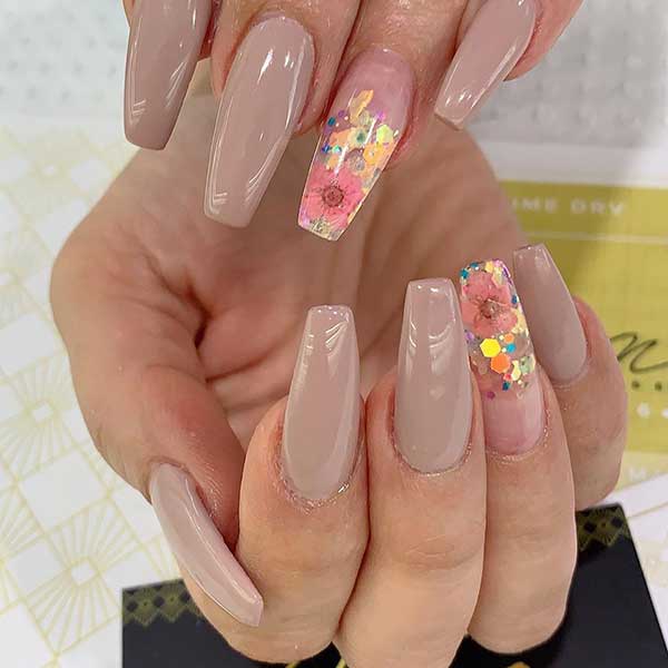 Best of coffin nail designs consists of nude coffin nails set with accent floral nail