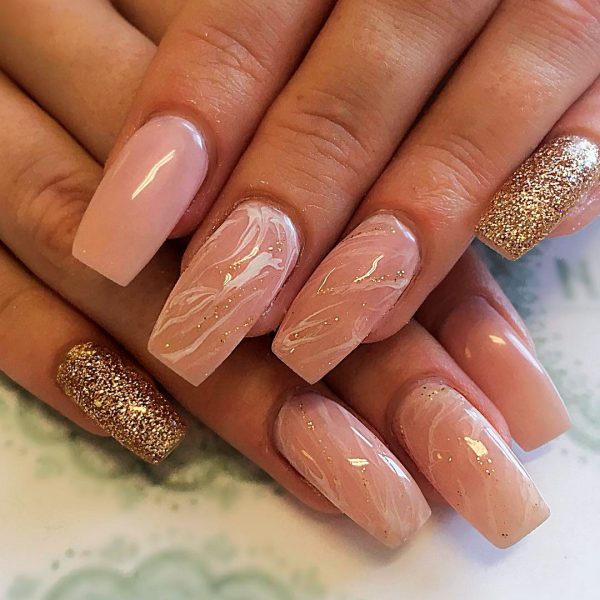nude marble coffin nails with a little glitter and one nude nail and one gold glitter nail!