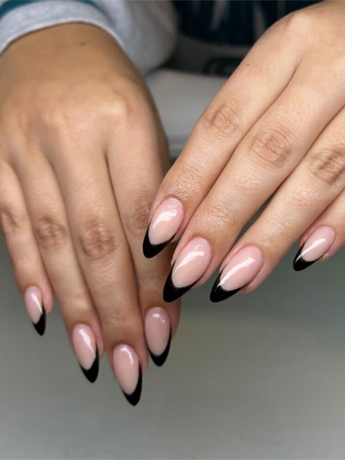 Almond-shaped short acrylic nails featuring bold black tips on a nude base, perfect for a stylish and edgy everyday manicure. Almond-shaped short acrylic nails featuring bold black tips on a nude base, perfect for a stylish and edgy everyday manicure.