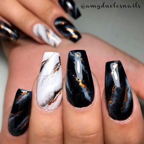 Gorgeous black marble nails with gold strips and an accent white marble nail!