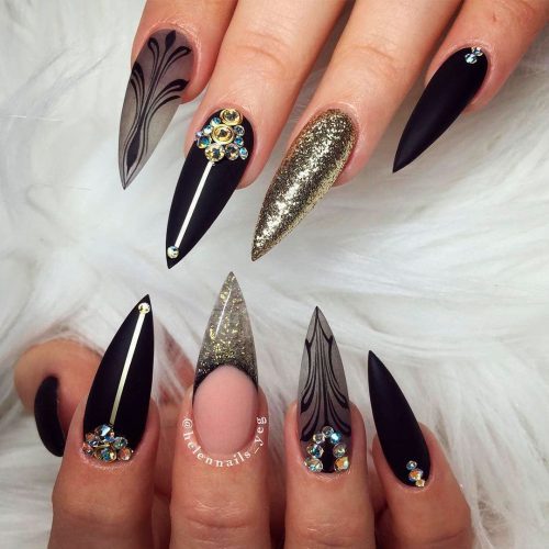 Cute black stiletto nail designs with gold glitter tips, an accent gold glitter nail, and cute rhinestones!