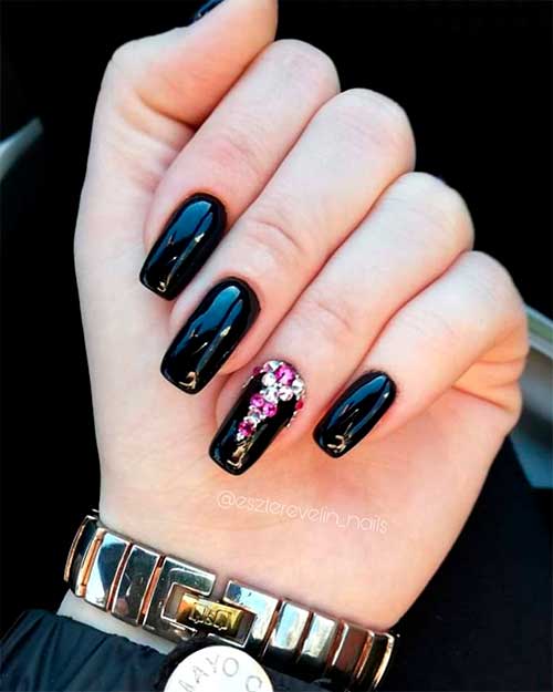 Amazing glossy black acrylic nails adorned with rhinestones on an accent nail!