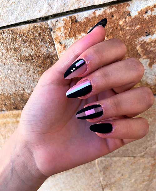 Cute black almond nails matte with white and pink strips and adorned with some rhinestones!