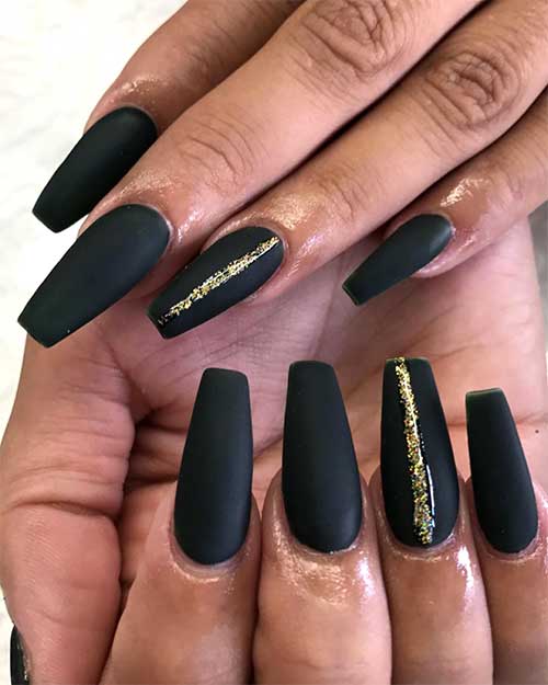 Gorgeous matte black coffin nails with gold glitter on an accent nail!