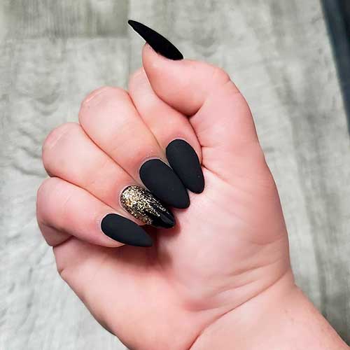 Matte black almond nails with gold glitter on accent shiny nail!