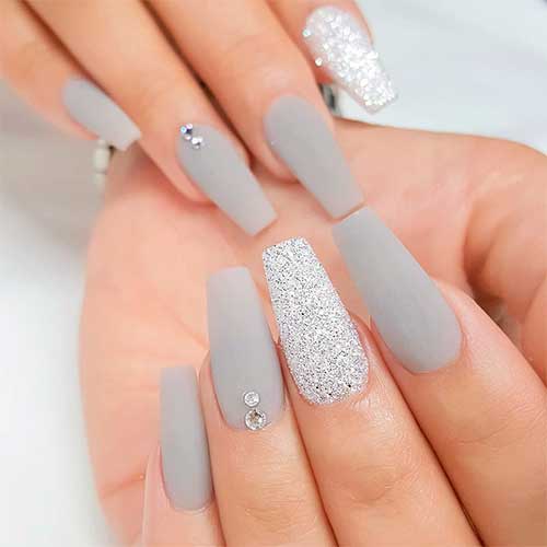 Cute light grey matte acrylic nails coffin shaped with rhinestones and glitter accent nail silver design!