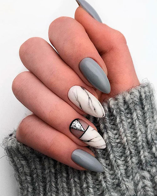 Grey and white marble almond nails consists of three medium gray shade almond nails and two white marble nails