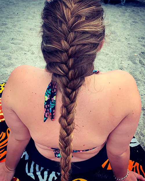 A girl on the beach with a single long French Pigtail Braids