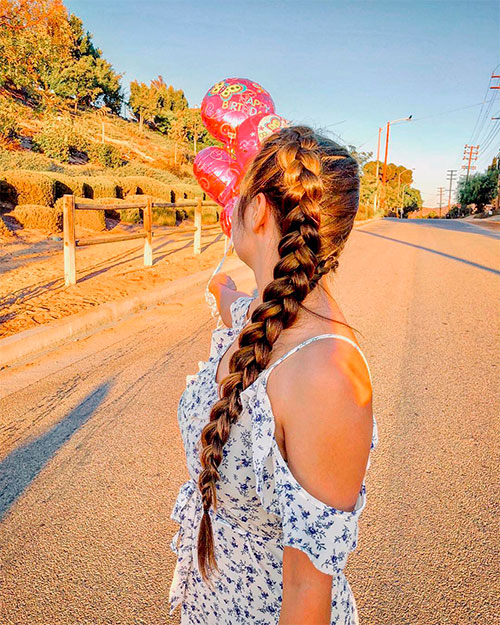 Girl on the street with cute single Dutch pigtail braid under sun rays