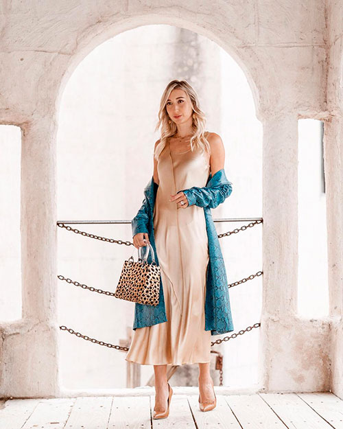 Woman wears ivory slip dress under a printed light blue coat in spring 2019