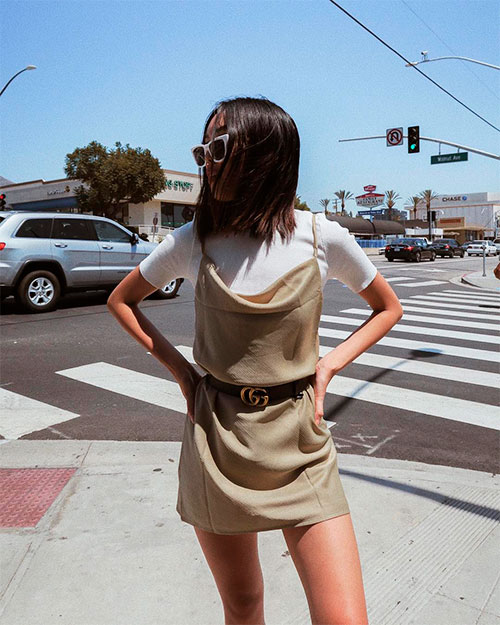 Girl in the street wears dark ivory short slip dress with a white T-shirt as a top underneath the dress for spring 2019