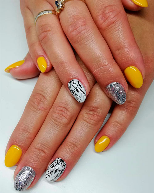 Cute yellow acrylic nails short with an accent silver glitter nail and accent white nail with a black stamp