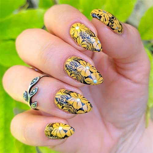 One of the cutest sunflower nail designs that consists of yellow sunflowers on summer almond nails with black base color!
