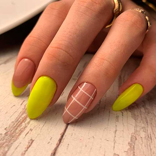 Cute yellow nails almond shape with accent French tip nail, and white strips on nude accent nail design!