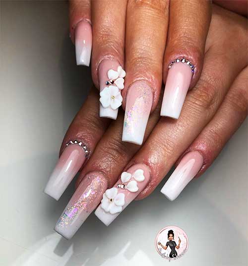 Coffin shaped french ombre acrylic nails with glitter, rhinestones, and 3d flowers on accent nail