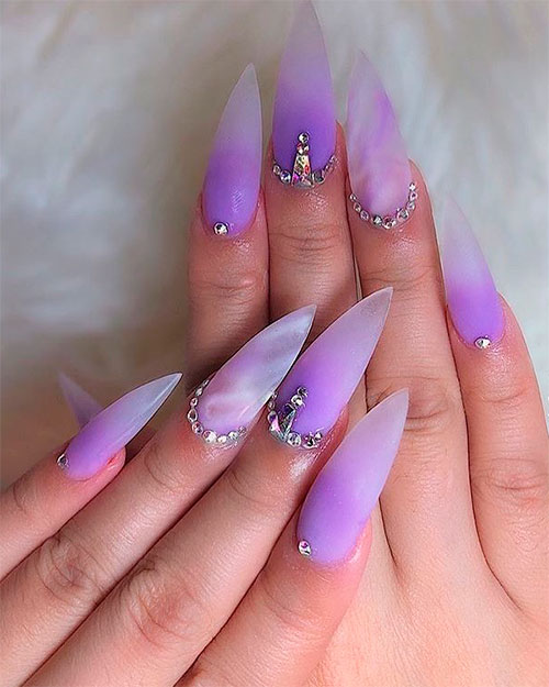 Fancy stiletto purple ombre nails adorned with crystals for summer 2019