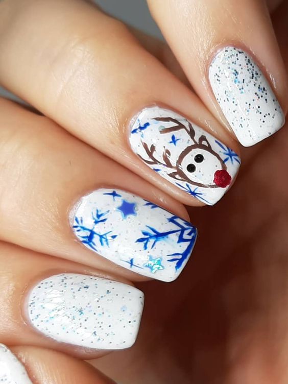 Cute glitter white winter nails design with snowflakes and reindeer on accent nail!