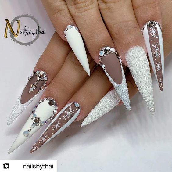 Cute white winter nails with white glitter, rhinestones, and snowflakes!