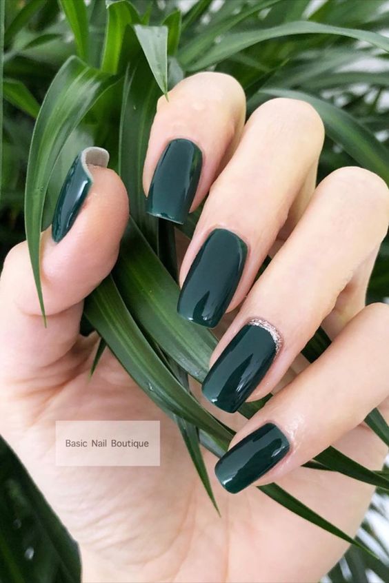 Gorgeous glossy dark green nails set with gold glitter on accent nail!