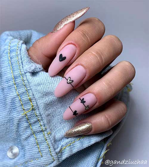 Cute valentines day nails 2020 pink almond shaped with black hearts and gold glitter accent nail