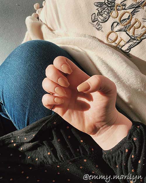 Cute acrylic nails nude coffin shaped set for stunning look with black top and denim pants Cute acrylic nails nude coffin shaped set for stunning look with black top and denim pants