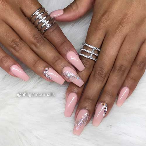 Nude coffin nails 2020 with glitter on accent nail and some rhinestones on accent ring fingernail
