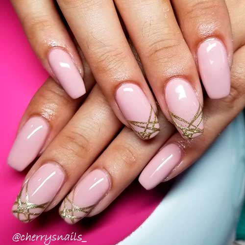 Nude pink coffin nails with gold glitter lines on tips