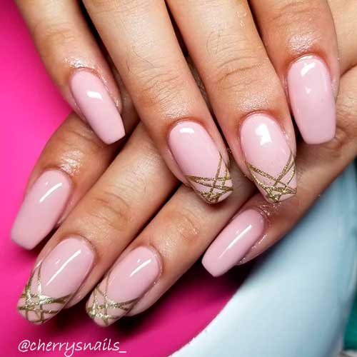 Nude pink coffin nails with gold glitter lines on tips Nude pink coffin nails with gold glitter lines on tips