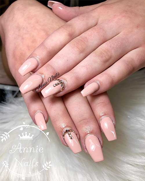 Simple nude coffin nails design with gold rhinestones on accent nail Simple nude coffin nails design with gold rhinestones on accent nail