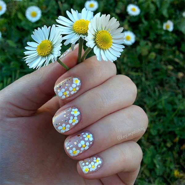 Cute nude short spring nails 2020 with white flowers and glitter design Cute nude short spring nails 2020 with white flowers and glitter design