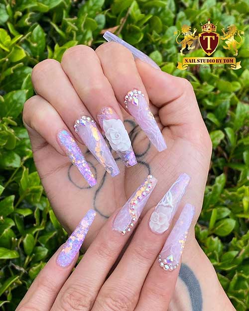 Gorgeous pastel purple spring nails coffin shaped with glitter, rhinestones, and accent floral nail design that can work as bridal nails 2020!