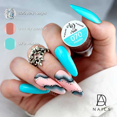 Long almond shaped aqua blue nails with pink accents adorned with black and silver glitter swirls