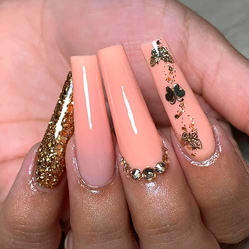Long Coffin Peach Nails with Gold Glitter, Rhinestones, and Butterflies for Summer 2022