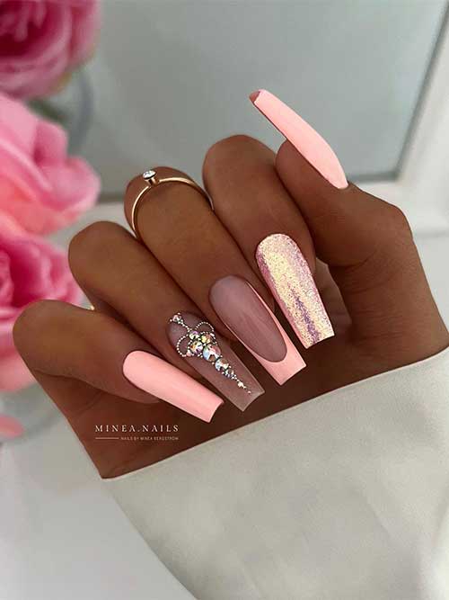 Long square shaped peach nails with rhinestones, glitter, and a French accent nail
