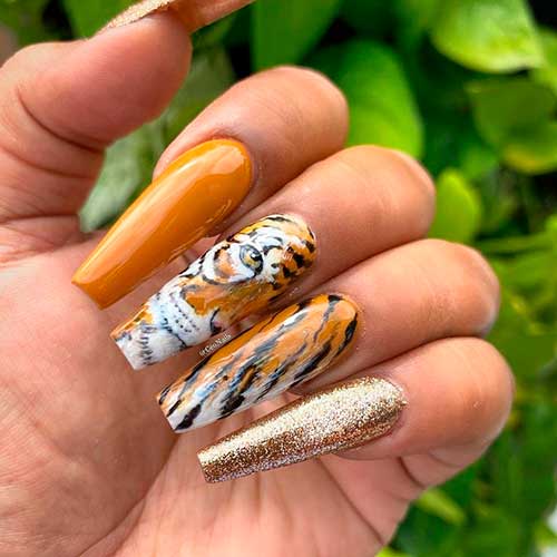 Mustard yellow tiger nails with accent gold glitter nail is a perfect fall nails 2021 to wear