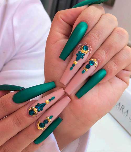 Cute long coffin emerald green nails 2021 with two accent nude nails adorned with emerald and gold rhinestones