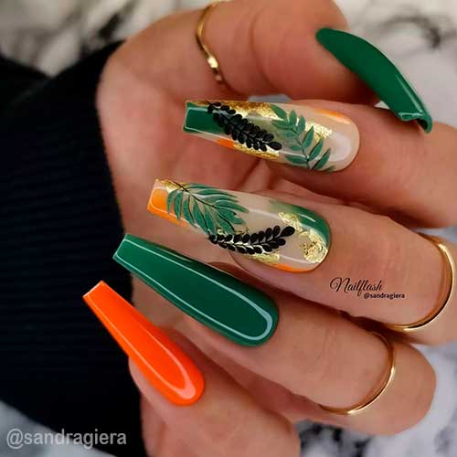 Cute dark green nails coffin shaped with two accent green, nude, orange nail art adorned with green and black fall leaves