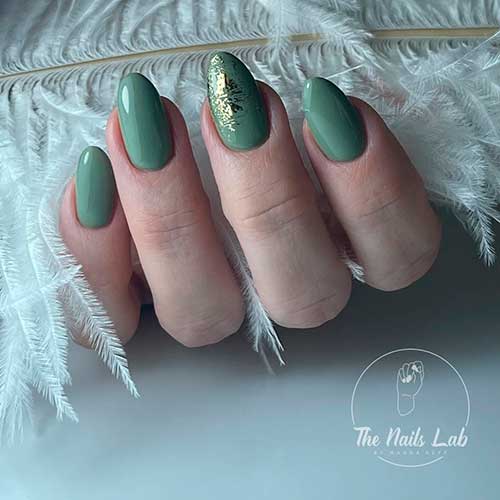 Short almond shaped sage green nails 2023 with gold foil on an accent nail