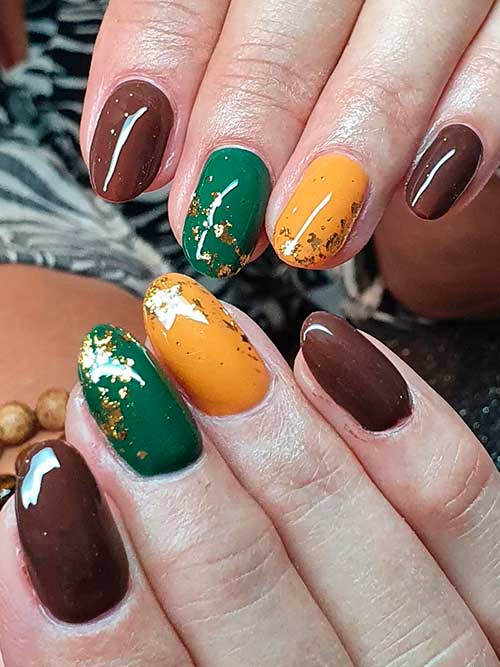 Dark Brown Nails with Green and Yellow Nail Accents Adorned with Gold Foil flakes
