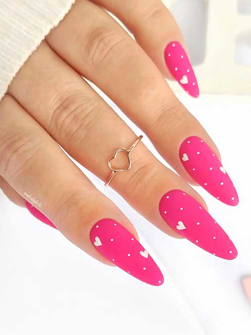 Long almond-shaped matte pink valentine’s day nails 2023 with white polka dots and small heart shapes